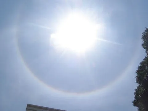 Matahari dikelilingi awan gelap dan pelangi