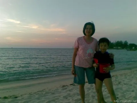 Brian dan Elly tengah berpose di tepi pantai